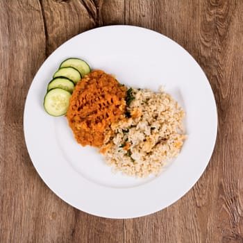 Vegetarian food on a white plate with wooden background