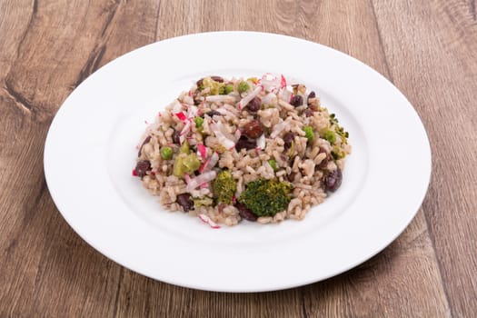 Vegetarian food on a white plate with wooden background