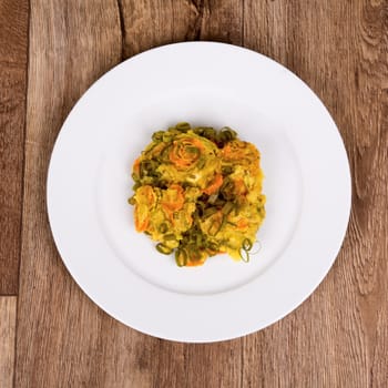 Vegetarian food on a white plate with wooden background