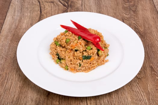 Vegetarian food on a white plate with wooden background