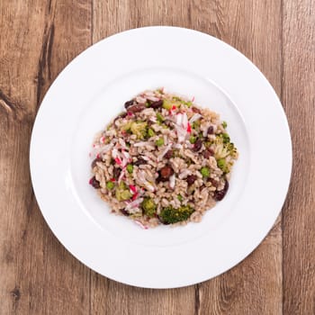 Vegetarian food on a white plate with wooden background