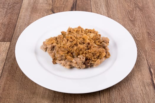 Vegetarian food on a white plate with wooden background