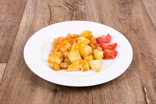 Vegetarian food on a white plate with wooden background