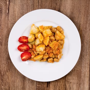 Vegetarian food on a white plate with wooden background