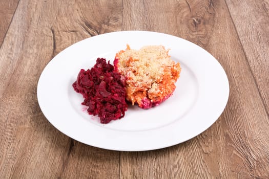 Vegetarian food on a white plate with wooden background