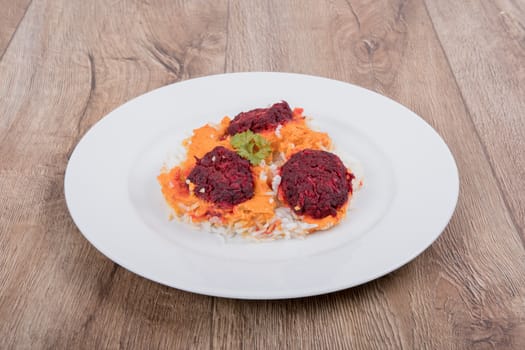 Vegetarian food on a white plate with wooden background