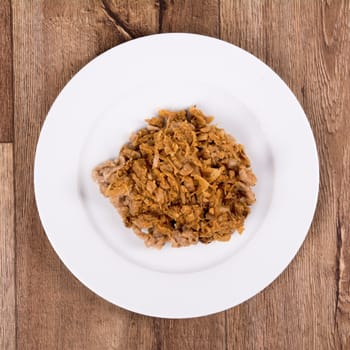 Vegetarian food on a white plate with wooden background