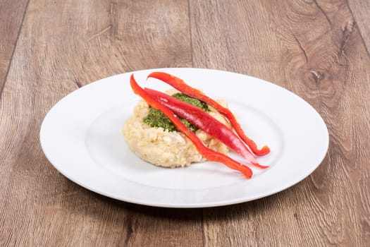 Vegetarian food on a white plate with wooden background