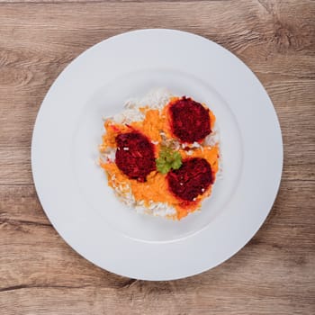 Vegetarian food on a white plate with wooden background