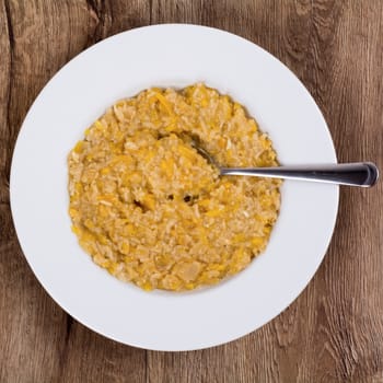 Vegetarian food on a white plate with wooden background