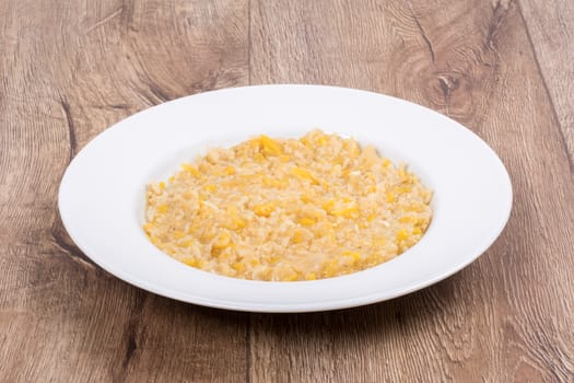 Vegetarian food on a white plate with wooden background