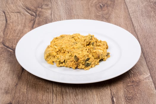 Vegetarian food on a white plate with wooden background