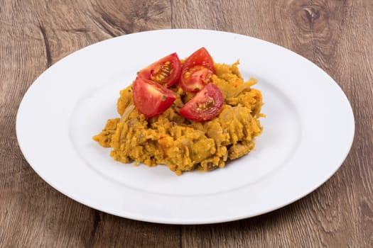Vegetarian food on a white plate with wooden background