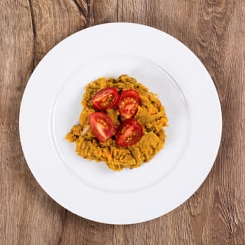 Vegetarian food on a white plate with wooden background