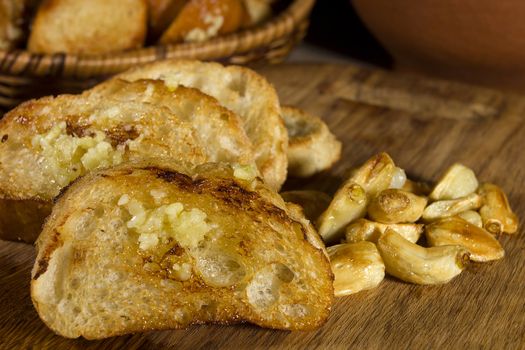 Fried garlic bread and garlic closeup on a wooden board