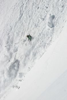 Freerider in an avalanche on the slope of the mountain