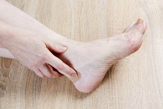 Female foot and hand close-up on a wooden background