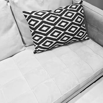 Black and white ornamental cushion on a gray sofa. Stylish modern furniture.