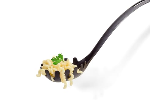 Some cooked helix shaped pasta and small parsley twig on the black plastic spaghetti spoon closeup on a light background
