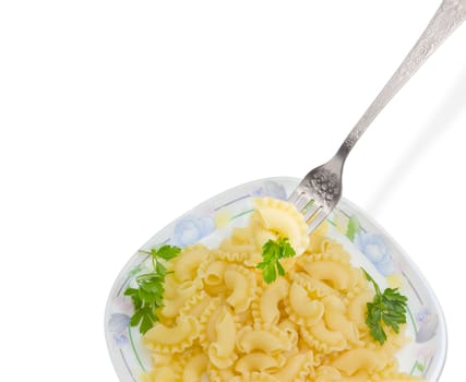 Fragment of the stainless steel fork with some cooked curved and ruffled pasta and the small parsley twig over of a dish with the same pasta on a light background
