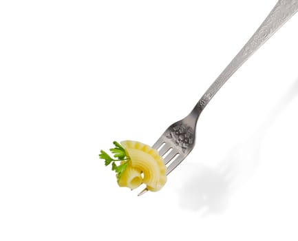 Cooked curved and ruffled pasta and small parsley twig on the stainless steel fork closeup on a light background
