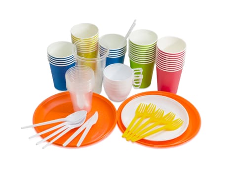 Orange and white disposable plastic plate, spoons, forks and knives, disposable paper cups in different colors, different white and transparent disposable plastic cups on a light background
