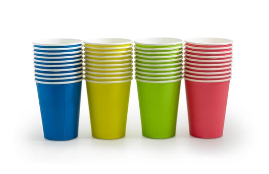 Row of the piles of the disposable paper cups in red, green, blue and yellow colors on a light background
