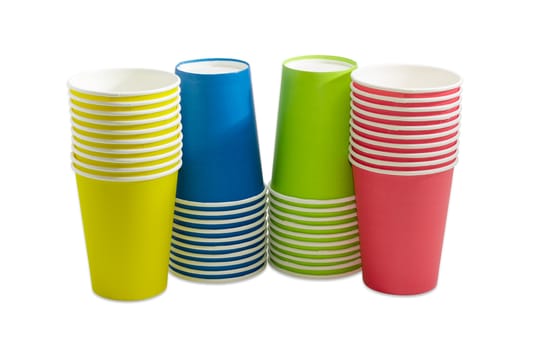 Four piles of the disposable paper cups in red, green, blue and yellow colors on a light background
