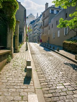 Old street covered with paving stones on the Montmartre hill in Paris, France
