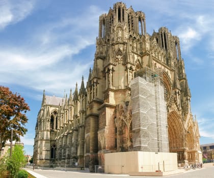 View from northwest of the Cathedral Notre-Dame de Reims, built in the 13th century, during the restoration work of a part of the main facade, France
