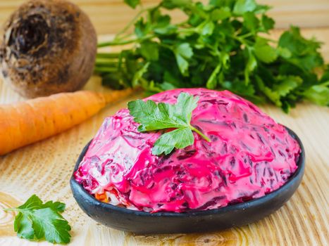 Close up view of homemade herring under a fur coat and ingredients. National festive Russian dish with beetroot. Served with fresh parsley