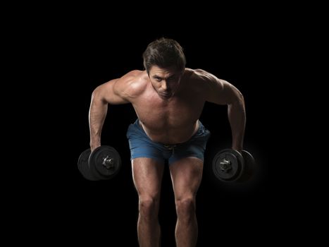 Muscular man doing exercises with dumbbells for back, isolated on black background
