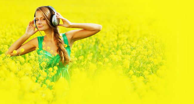 Girl listening to music on oilseed field