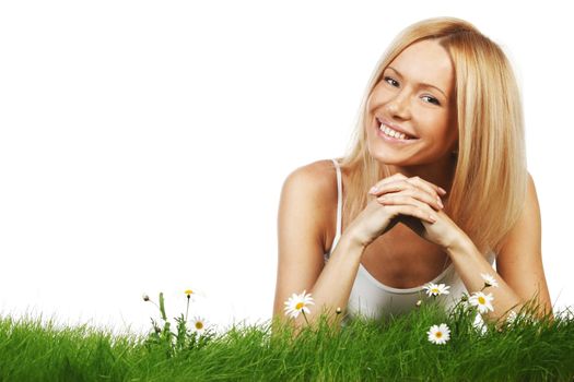 Beautiful young blonde woman lying on grass with chamomile flowers, isolated on white background