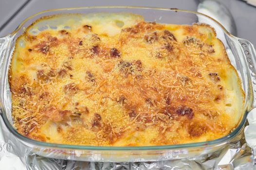 potato casserole with cheese in a glass bowl