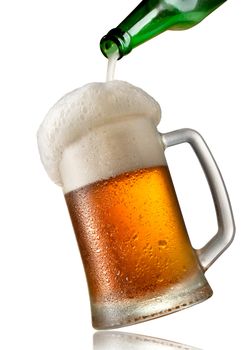 Beer pouring into mug isolated on a white background