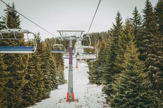 Ropeway and chair lifts driving at ski resort on beautiful snowing day. Landscape.