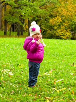 smiling girl in a white hat on a background of green meadows