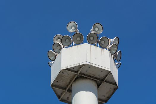 Many speakers on a high tower against a clear sky background.