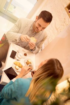 Young smiling businesspeople on a break in a cafe. They are drinking coffee and talking with smile. Selective focus.