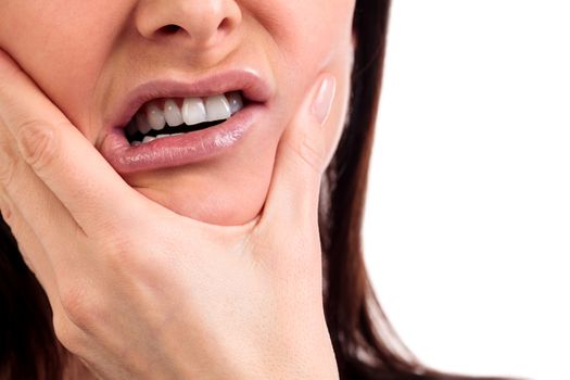 Closeup of woman in strong toothache pain with hands over face. Dental health and care concept. Isolated on white background.