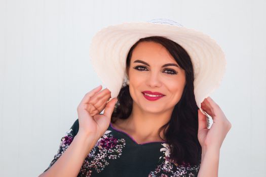 Vintage girl with beautiful floral dress with a white hat.