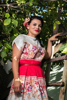 Vintage girl with floral dress climbing a lemon tree.