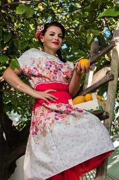 Vintage girl with floral dress climbing a lemon tree.