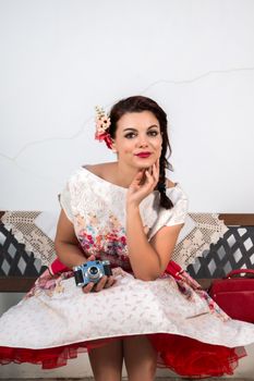 Vintage girl with floral dress relaxing on a park bench.