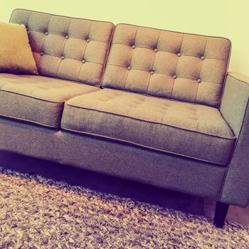 Retro style elegant and comfortable sofa on a knitted rug.