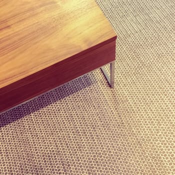 Simple wooden table on carpet floor. Modern design.