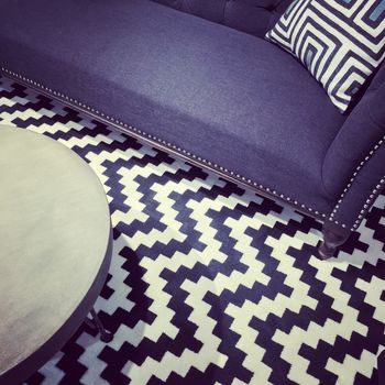 Luxurious modern furniture. Sofa and coffee table on ornamental carpet.
