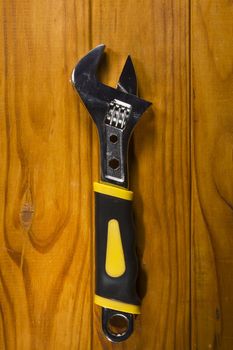 New adjustable wrench on a wooden background