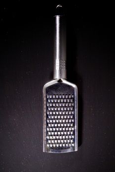 Metallic shiny grater on a black background